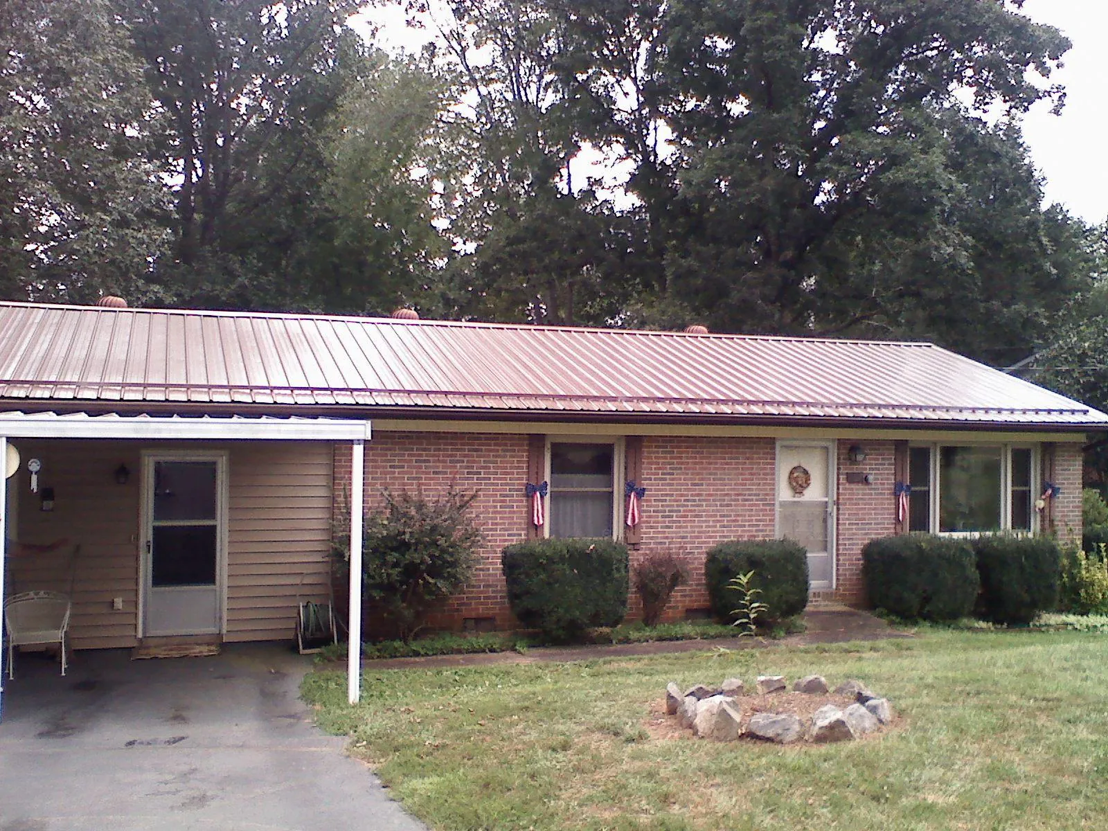 Bronze metal roof and carport on a brick ranch home — Roof Repair work by our crew in Pacific City